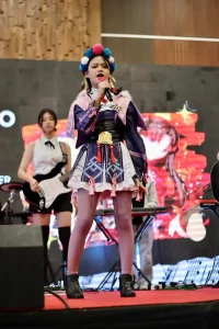 Young female vocalist performing live on stage in colorful costume with band accompaniment from Legato Music events