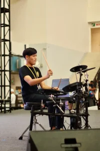 Drummer practicing drum kit during music lesson or performance session at Legato Music